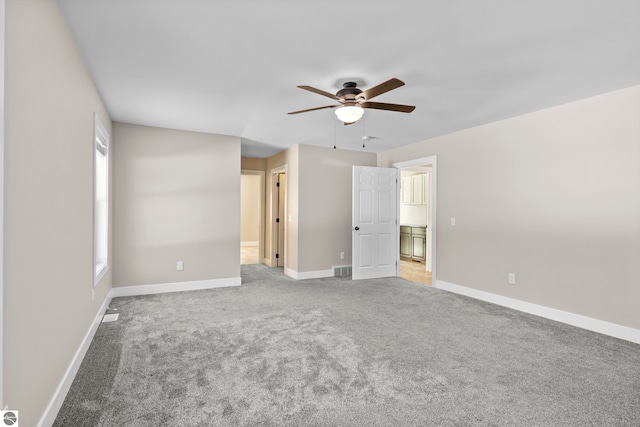 unfurnished bedroom featuring light colored carpet, ceiling fan, visible vents, and baseboards