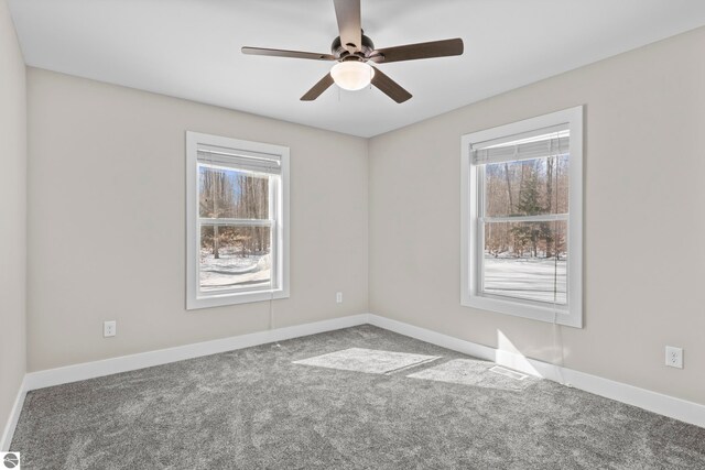 spare room featuring carpet, baseboards, and a ceiling fan