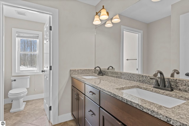 full bath with toilet, double vanity, baseboards, and a sink