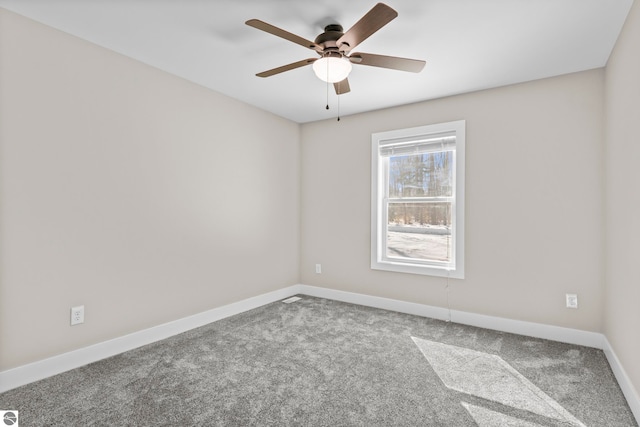 carpeted spare room with ceiling fan and baseboards