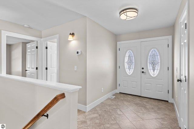 entryway with baseboards and light tile patterned flooring