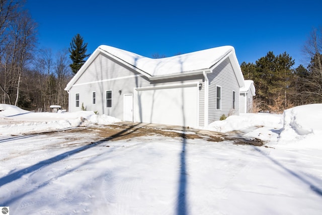 view of snowy exterior with a garage