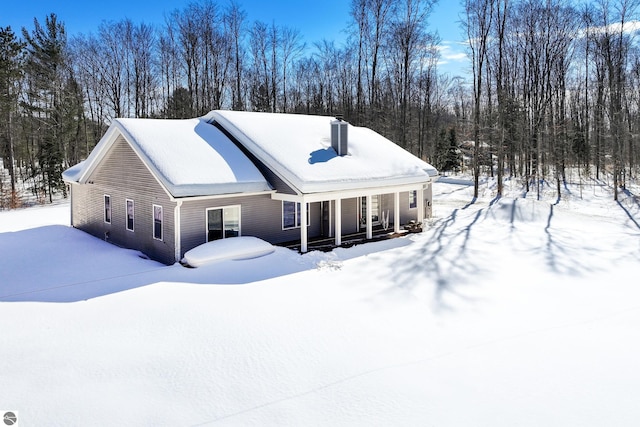 view of front of house with covered porch and a chimney