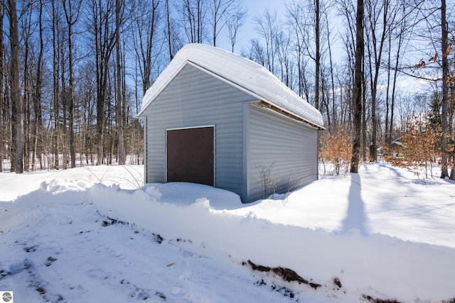 snow covered garage with a detached garage