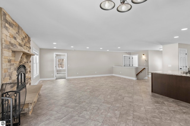 unfurnished living room with recessed lighting, a fireplace, and baseboards