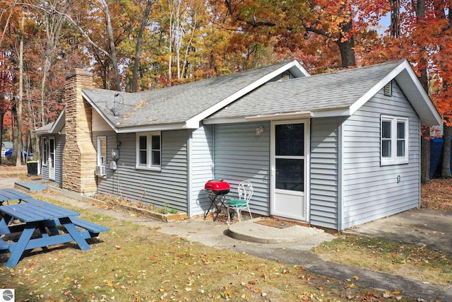 view of front of property featuring roof with shingles and a chimney