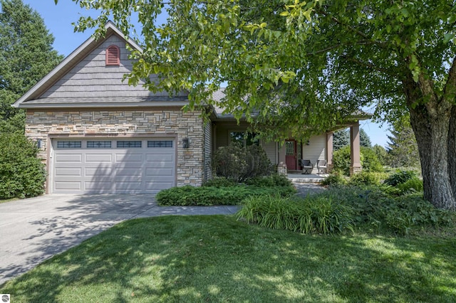 view of front of house featuring a porch, a garage, stone siding, driveway, and a front yard