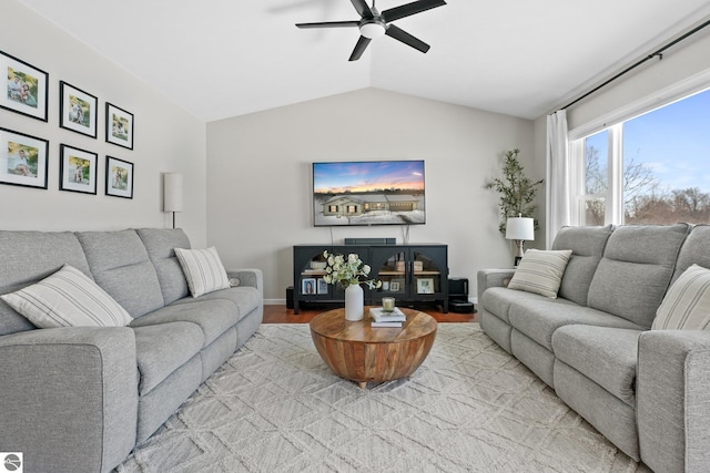 living room with vaulted ceiling, light wood finished floors, a ceiling fan, and baseboards