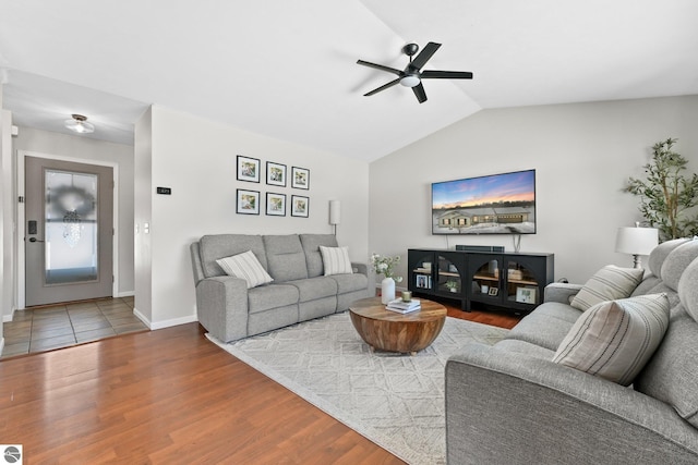 living room featuring vaulted ceiling, wood finished floors, a ceiling fan, and baseboards