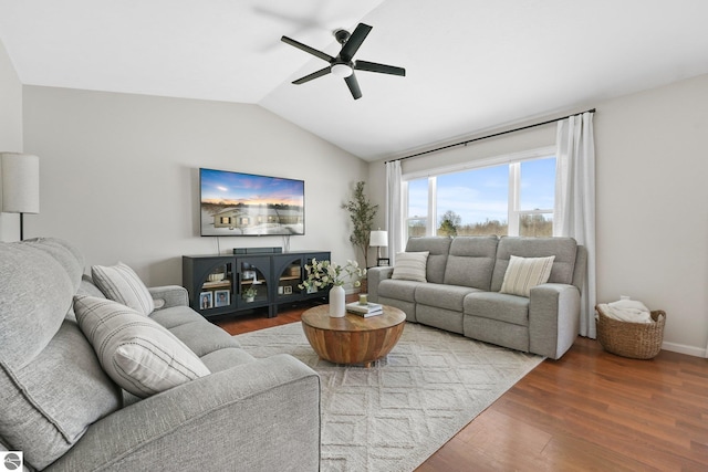 living room featuring lofted ceiling, baseboards, a ceiling fan, and wood finished floors