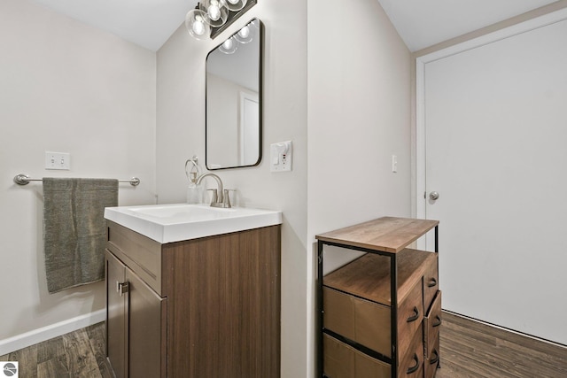 bathroom featuring baseboards, wood finished floors, and vanity