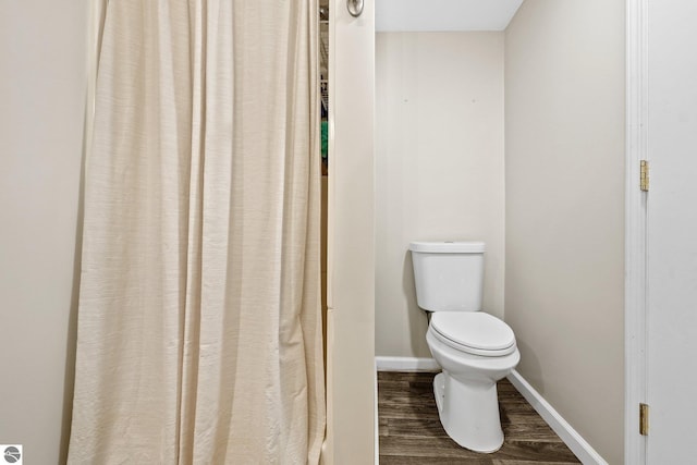 bathroom featuring wood finished floors, toilet, and baseboards