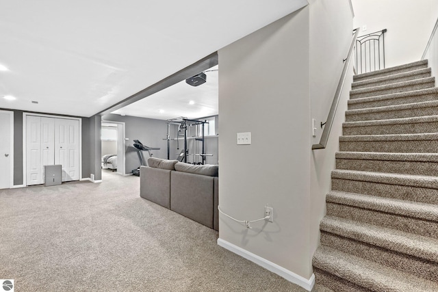 living room with stairway, carpet flooring, and baseboards