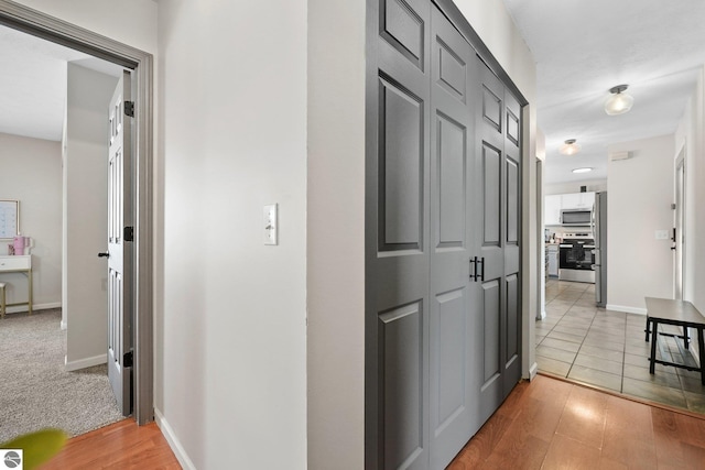 hall featuring baseboards and light wood finished floors