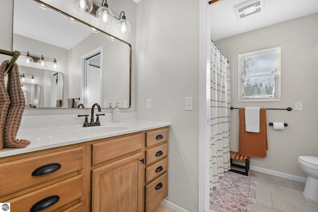 bathroom with baseboards, visible vents, toilet, tile patterned floors, and vanity