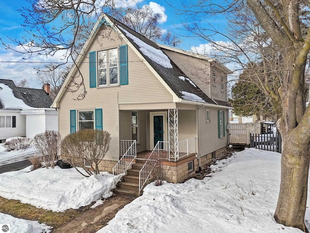 view of front of home featuring roof with shingles and fence