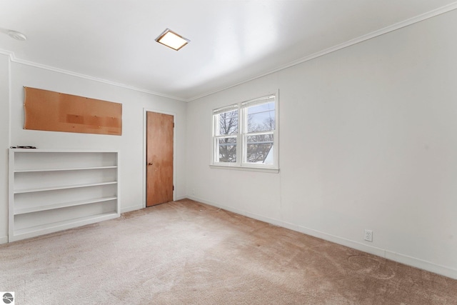 unfurnished bedroom featuring ornamental molding, light colored carpet, and baseboards