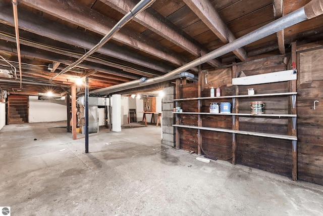 unfinished basement featuring heating unit