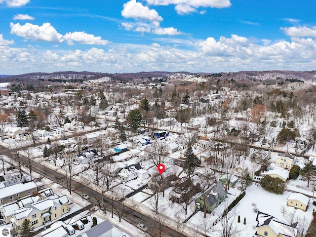 snowy aerial view with a residential view and a mountain view