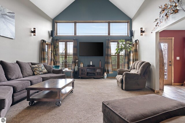 living area with high vaulted ceiling and carpet floors