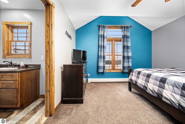 bedroom with lofted ceiling, light colored carpet, a baseboard heating unit, a sink, and baseboards