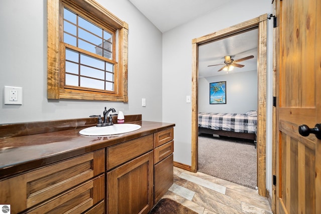 bathroom with a ceiling fan, connected bathroom, vanity, and baseboards