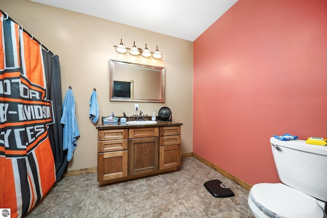 bathroom featuring tile patterned floors, vanity, toilet, and baseboards