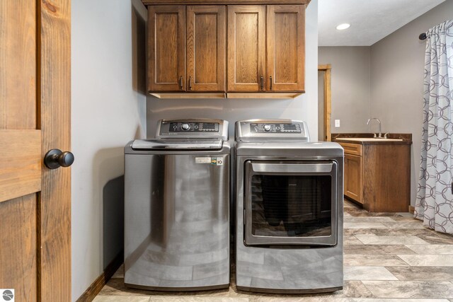 laundry area with recessed lighting, a sink, baseboards, independent washer and dryer, and cabinet space