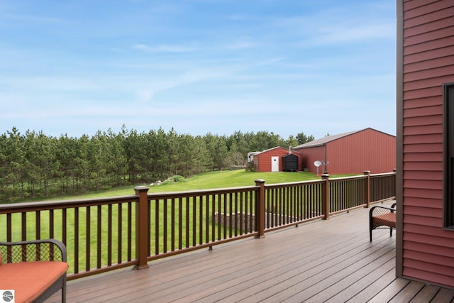 deck with an outbuilding, a yard, and a shed