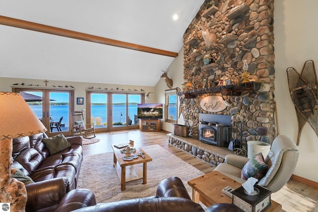 living room featuring high vaulted ceiling, a fireplace, baseboards, light wood-style floors, and beamed ceiling