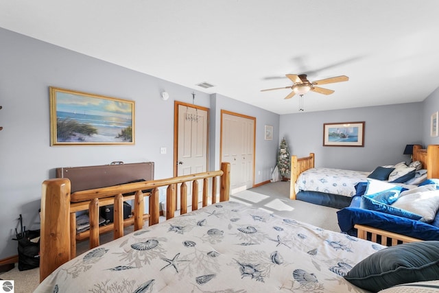 bedroom with light colored carpet, ceiling fan, visible vents, and baseboards