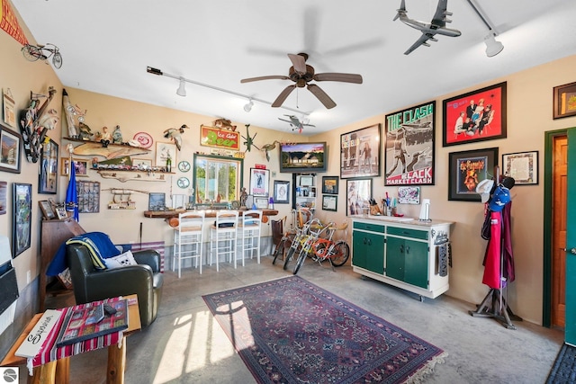 recreation room featuring rail lighting and ceiling fan