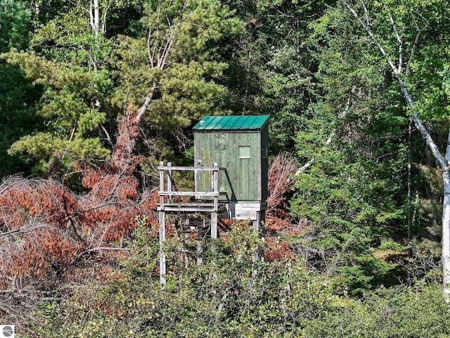 view of shed featuring a forest view