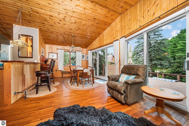 interior space with light wood-style floors, lofted ceiling, wooden ceiling, and wood walls