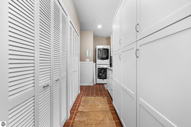 hallway featuring dark tile patterned flooring, stacked washer / dryer, wainscoting, and recessed lighting