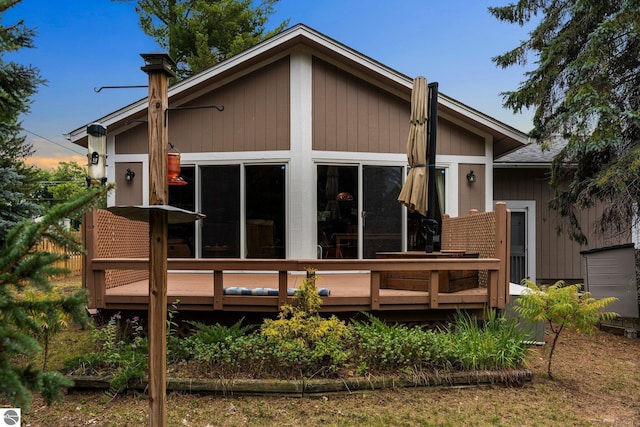 rear view of house featuring a wooden deck