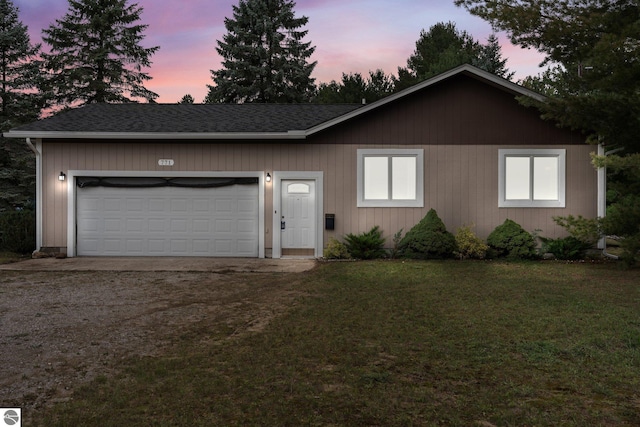 ranch-style house with a front lawn, a shingled roof, and dirt driveway