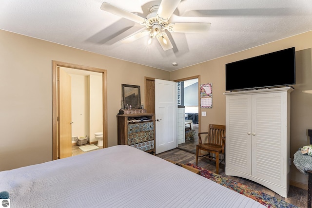 bedroom with a textured ceiling, connected bathroom, a ceiling fan, and dark wood-type flooring