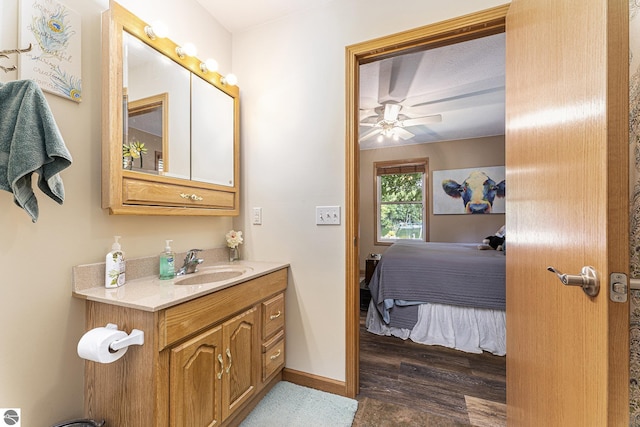 bathroom featuring baseboards, ensuite bath, ceiling fan, wood finished floors, and vanity