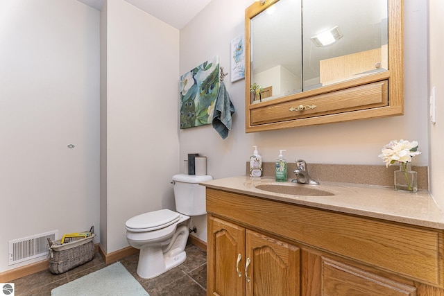 bathroom featuring visible vents, toilet, vanity, baseboards, and tile patterned floors