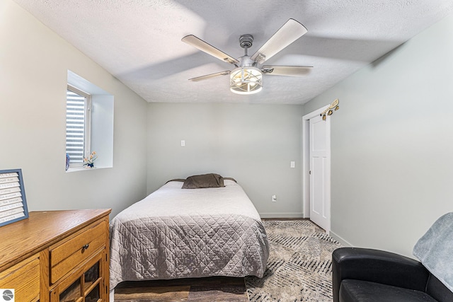 bedroom with a textured ceiling, ceiling fan, and baseboards