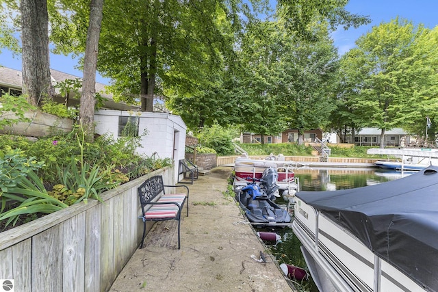 view of yard featuring a boat dock, a water view, and fence