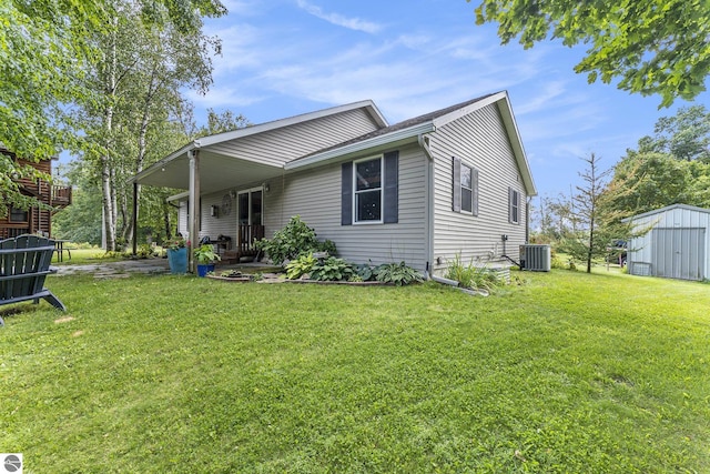view of front of home with a storage unit, a front yard, cooling unit, and an outdoor structure
