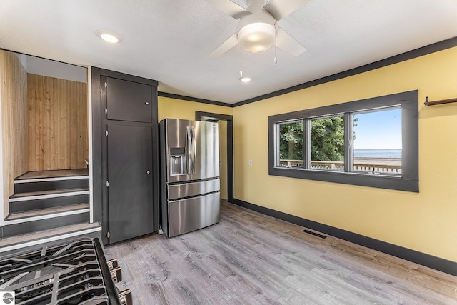 kitchen with baseboards, visible vents, ceiling fan, light wood-type flooring, and stainless steel refrigerator with ice dispenser