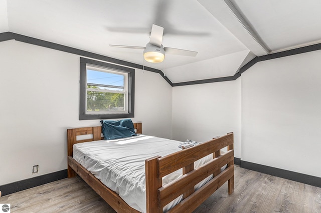 bedroom with lofted ceiling, ceiling fan, baseboards, and wood finished floors