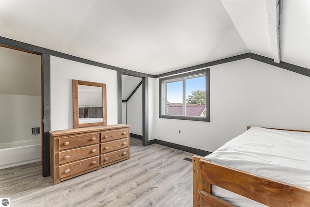 bedroom with lofted ceiling, light wood-style floors, and baseboards