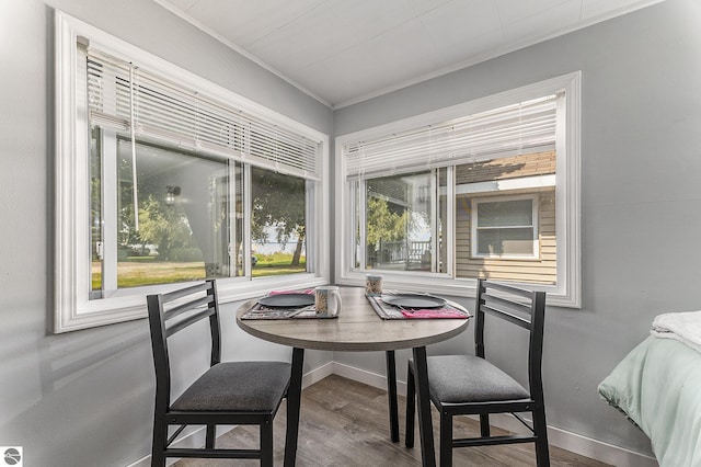 dining area featuring baseboards, ornamental molding, and wood finished floors