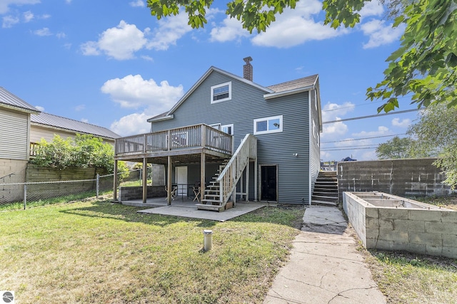 rear view of house with a vegetable garden, a chimney, a lawn, a fenced backyard, and stairs