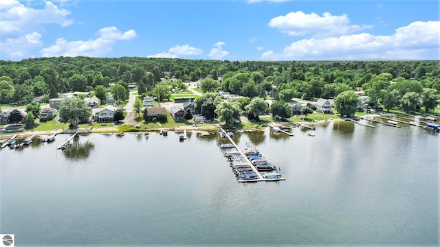 drone / aerial view featuring a water view and a wooded view