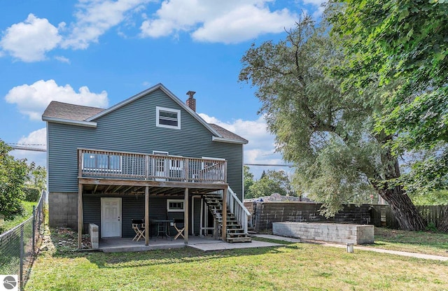 back of house featuring a lawn, a patio area, a fenced backyard, and a wooden deck